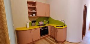 una piccola cucina con un bancone giallo e un lavandino di Urlaubsnest Das Künstlerrefugium a Bleckede