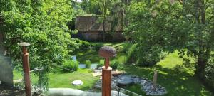 un giardino con un microfono e uno stagno di Urlaubsnest Das Künstlerrefugium a Bleckede