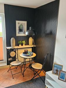 einen Tisch und Stühle in einem Zimmer mit schwarzer Wand in der Unterkunft Kapitänshaus - Zickenstube in Barth