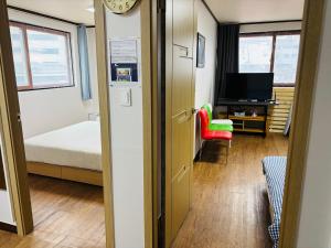 a room with a room with a bed and a clock at Travel Apartment in Seoul