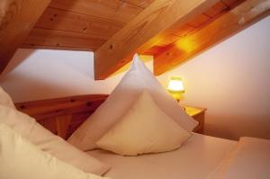 a pile of pillows on a bed with a lamp at Gänseblümchen -805- in Mittenwald