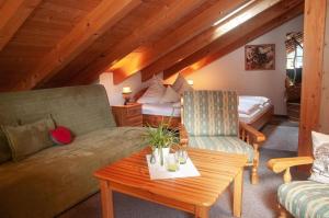 a living room with a couch and a bed at Gänseblümchen -805- in Mittenwald
