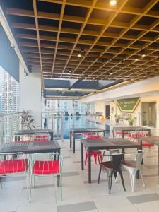 a cafeteria with tables and chairs in a building at Cozy 1 Studio Room - The Residences BGC Taguig in Manila
