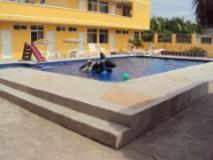 two dogs are playing in a swimming pool at HOTEL SUNSHINE AIRE ACND y WIFI ZONE in Tonsupa