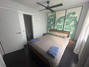a bedroom with a bed with a painting on the wall at A modern two bedroom apartment! Quiet, secure and 1 minute walk to Bondi Beach! in Sydney