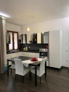 a kitchen with a black table and white chairs at Grazioso appartamento in Fermignano