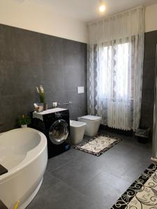 a bathroom with a tub and a toilet and a sink at Grazioso appartamento in Fermignano +7 photos