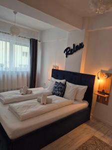 a bedroom with two beds and a sign on the wall at Angel apartament in Sibiu