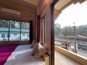 a bedroom with a bed and a large window at Green Earth Resort in Lataguri