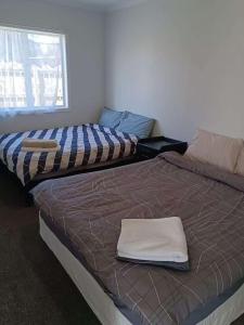 Un pat sau paturi într-o cameră la 5 Beds including 3 Double Beds plus 1 Double or 2 Single Sofa Beds House at 22B Pererika St