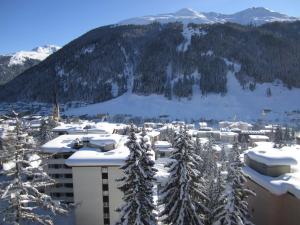 a city covered in snow with a mountain in the background at Apartment Alpenblick Superior in Davos