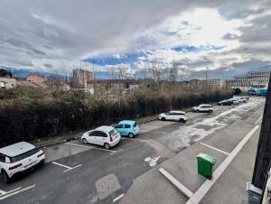 un groupe de voitures garées sur un parking dans l'établissement Bright & Spacious 2-Bedroom Apartment - Parking & Close to Train Station & Downtown, à Grenoble 7 autres photos
