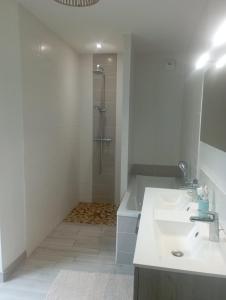 a white bathroom with a sink and a shower at Chambre chez l'habitant in Le Val-Saint-Père