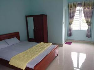 a bedroom with a bed and a large window at 35 Đinh Tiên Hoàng in Bao Loc