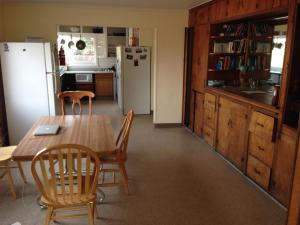 a kitchen with a table and chairs and a refrigerator at Base Camp Anchorage Hostel in Anchorage