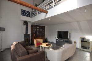 Una sala de estar con un sofá y un televisor. en Maison de campagne Jacuzzi, en Sceaux-du-Gâtinais