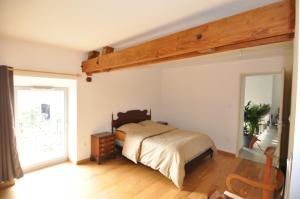 Un dormitorio con una cama y una ventana grande. en Maison de campagne Jacuzzi, en Sceaux-du-Gâtinais