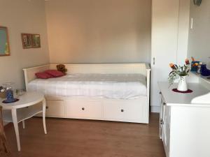 een slaapkamer met een wit bed en een tafel bij Sjötomt Borshult in Diö