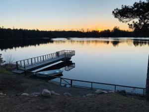 a dock in the middle of a lake at sunset at Ferienhaus Valle-Sjötomt Borshult in Diö