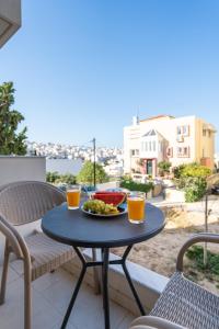 a table with a plate of food on a balcony at Brand New House Sitia in Sitia