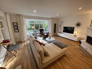 LangballigMeerZeit的配有沙发和电视的大客厅