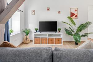 a living room with a couch and a flat screen tv at Charming T4 - Cosy Air Conditioning in Béziers +18 photos