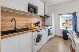 a kitchen with a washing machine and a sink at Charming T4 - Cosy Air Conditioning in Béziers