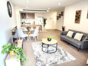 ブリスベンにあるSpacious River View Escape with Free Secure Park - 2BR, 2BA and Sofa Bedのソファとテーブルのあるリビングルーム