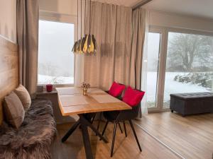a dining room with a table and red pillows on it at Panorama-Domizil Tauchershof in Lauf an der Pegnitz