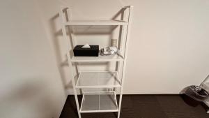 a white book shelf with a box on it at Slopeside Lodge Hakuba in Otari