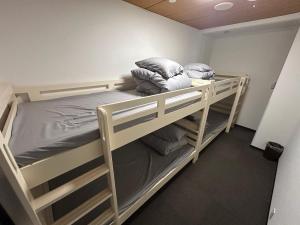 a bedroom with two bunk beds with pillows at Slopeside Lodge Hakuba in Otari