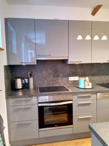 a kitchen with stainless steel appliances and white cabinets at Ferienwohnung im Mittelpunkt in Nortorf