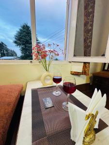 戴尔豪斯Hotel Mini Switzerland In Dalhousie #Air Cooled的一张桌子,上面放着两杯葡萄酒,还有一个窗口