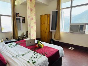 戴尔豪斯Hotel Mini Switzerland In Dalhousie #Air Cooled的一间卧室配有一张带笔记本电脑的床