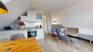 a kitchen and living room with a table and chairs at Neehuus Wohnung 5 in Borkum +9 photos