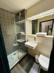 une salle de bains avec douche, toilettes et lavabo dans l'établissement B&B HOTEL Saint-Witz Roissy, à Saint-Witz