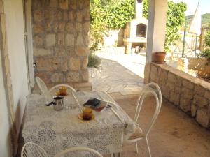 a white table and chairs on a patio with a table and chairs at Apartments Boa in Slatine +17 photos