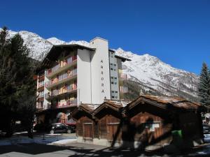 a building in front of a mountain with snow at Aurora Appartement LAGGIN by FeWo-PLAN SAAS231 in Saas-Grund