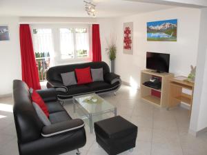 a living room with two chairs and a couch and a tv at Aurora Appartement LAGGIN by FeWo-PLAN SAAS231 in Saas-Grund
