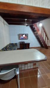 卡拉瓜塔图巴Casa com Piscina em Caraguatatuba的客厅配有大桌子和电视