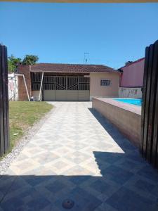 卡拉瓜塔图巴Casa com Piscina em Caraguatatuba的车道,位于带游泳池的房屋前 更多11张照片