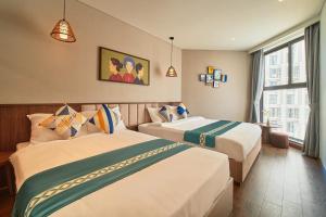 ein Hotelzimmer mit zwei Betten und einem Fenster in der Unterkunft Apec Mandala Ocean Retreat - Mui Ne in Mui Ne + 37 Fotos