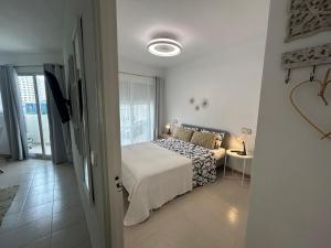a white bedroom with a bed and a window at Hernando II in Calpe