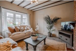 un salon avec un canapé et une table basse dans l'établissement Jasmine Cottage, à Skipsea