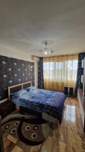 Un dormitorio con una cama con un edredón azul. en Apartament Back, en Galaţi