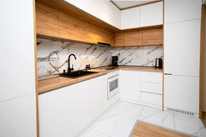 a kitchen with white cabinets and a sink at Cozy and Stylish Apartament in Stara Zagora