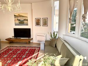 a living room with a couch and a flat screen tv at Capital Apartment Tirana in Tirana
