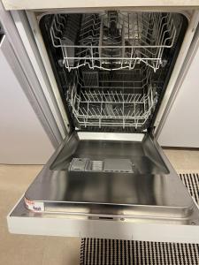 a dishwasher with its door open with a dish rack at Capital Apartment Tirana in Tirana