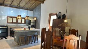 a kitchen with a counter and a table and chairs at Casa das Alpinias - Trancoso in Trancoso