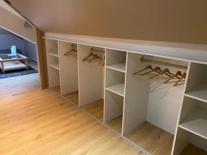 a walk in closet with white cabinets and wooden floors at duplex romantique in Clavier